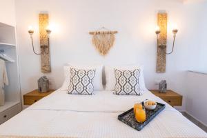 a bedroom with a bed with a tray of orange juice at Yploui Suites in Karpathos