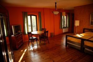 Schlafzimmer mit orangefarbenen Wänden sowie einem Tisch und Stühlen in der Unterkunft Seminar- und Gästehaus Flussbad Gartenstrasse in Berlin