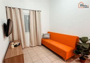 an orange couch in a living room with curtains at Casa 65 San Miguel in San Miguel
