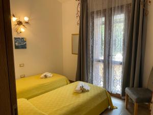 多木斯馬里亞的住宿－Residenza I Ginepri，窗户客房内的两张黄色床