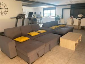 ein Wohnzimmer mit einem Sofa und gelben Kissen in der Unterkunft Villa des Grenadelles in Saint-Paul
