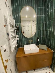 a bathroom with a sink and a mirror at La Halte des Arènes de Nîmes Emeraude, Havre de paix en ville in Nîmes