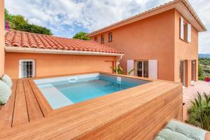 a swimming pool in front of a house at Oliveraie Furnished villa in Nice