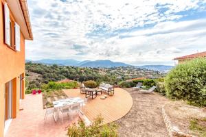 a patio with a table and chairs and a view at Oliveraie Furnished villa in Nice