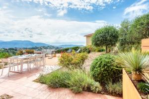 a garden with a table and chairs on a patio at Oliveraie Furnished villa in Nice
