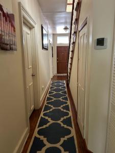 a hallway with a blue and white rug on the floor at 5 Minutes walk to VCU in Richmond