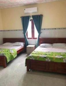 1 dormitorio con 2 camas y ventana en San Vuon Guesthouse en Mui Ne