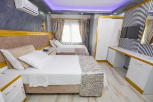 Habitación pequeña con 2 camas y TV. en Cihan Bey Otel Belek en Belek