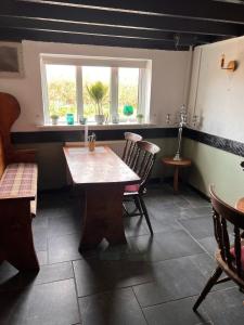 um quarto com uma mesa e cadeiras e uma janela em The Malt Shovel Inn em Bridgwater