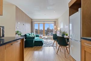 a kitchen and living room with a green couch at Stunning Views l Last-Minute Escape l Free Parking l Sleeps 6 l By Zen Nights Short Lets & Serviced Accommodations in Leicester