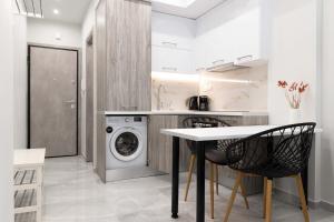 a kitchen with a washing machine and a table and chairs at SKG Modernity Studio in Thessaloniki
