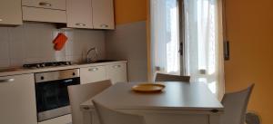 a kitchen with a white table and chairs and a window at "Casa Sofia" appartamento Raffalda ZONA CLINICA in Piacenza +24 photos