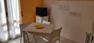 a small white table with chairs and a television at "Casa Sofia" appartamento Raffalda ZONA CLINICA in Piacenza