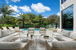 un soggiorno con mobili bianchi e una piscina di Villa Panaroma a Hallandale Beach