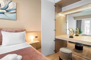 una camera da letto con un letto e una scrivania in una stanza di Sandy Breeze - Jacuzzi & Sauna Infinity Resort a Mamaia Nord - Năvodari Altre 47 foto
