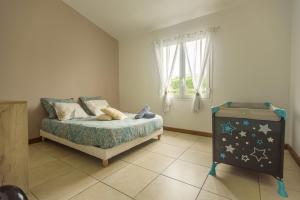 1 dormitorio con 1 cama, vestidor y ventana en Ti Kaz Bibass, en La Plaine-des-Palmistes