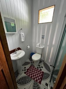 a bathroom with a toilet and a sink at Vista do Lago Jungle Lodge in Cajual