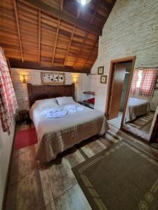 a bedroom with a large bed in a room at Pousada Vilas di Espanha in Monte Verde