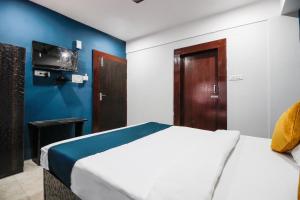 una camera con un letto bianco e una parete blu di SilverKey Hotel Sundari a Nunmāti