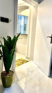 a potted plant sitting on a floor next to a door at Smart Entry Apartment in Riyadh