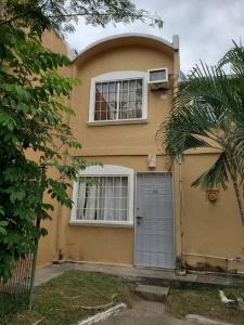 a yellow house with a door and two windows at Condominio 15, casa 3 Joyas de Ixtapa in Ixtapa
