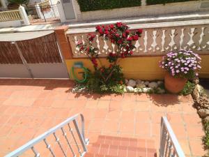 a patio with a fence and flowers and a bench at Casa a 85 metros playa 158 m2 4 dorm WIFI in Oliva
