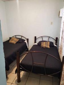 two twin beds in a room withthritisthritisthritisthritisthritisthritisthritisthritisthritis at Condominio 15, casa 3 Joyas de Ixtapa in Ixtapa