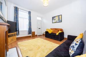 a living room with a couch and a tv at Cosy Two bedroom Terrace Blackburn in Cherry Tree