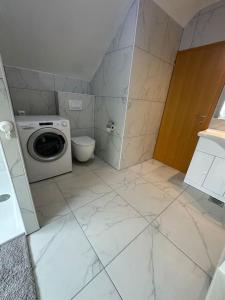 La salle de bains est pourvue d'un lave-linge et de toilettes. dans l'établissement Prostorno in prijetno stanovanje, à Smarjeske Toplice