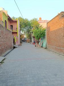 an empty street in an alley between two brick buildings at Keshav Narayan Home Stay in Mathura