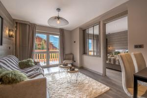 a living room with a couch and a table at Superbe Appartement au Plateau Rond-Point des Pistes Classé 3 Etoiles et Label Méribel in Les Allues