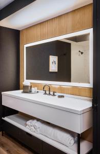 ein Badezimmer mit einem Waschbecken und einem großen Spiegel in der Unterkunft The Watershed - Formerly Hotel Zero Degrees in Norwalk