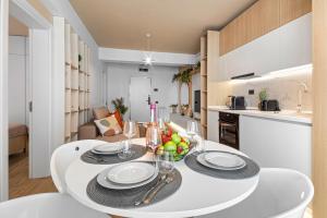 tavolo bianco da pranzo con ciotola di frutta di Sandy Breeze - Jacuzzi & Sauna Infinity Resort a Mamaia Nord - Năvodari