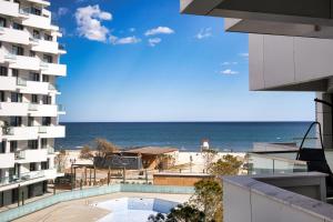 una vista della spiaggia dal balcone di un edificio di Sandy Breeze - Jacuzzi & Sauna Infinity Resort a Mamaia Nord - Năvodari