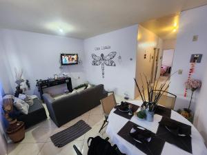 Una sala de estar con un sofá, mesas y un televisor. en Casa Libélula, en Tehuacán