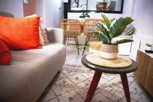 a living room with a couch and a table with a plant at Appartement Cosy et Chic - Ahala in Yaoundé