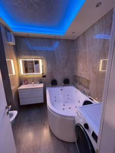 uma grande casa de banho com uma grande banheira e um lavatório em Luxury apartment em Tirana