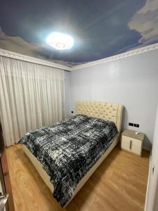 um quarto com uma cama com um edredão preto e branco em Luxury apartment em Tirana