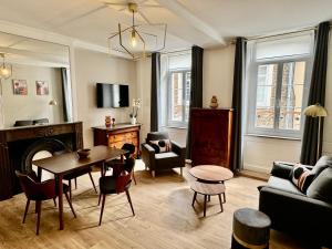 sala de estar con sofá y mesa en Les Suites de l'Enclos - L'Enclos de l'Evêché en Boulogne-sur-Mer