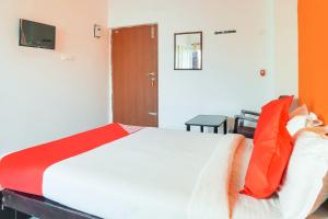 a bedroom with a bed with orange and white pillows at Flagship New Cresent Park in Irugūr