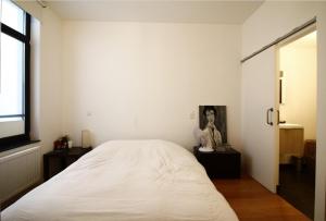 ein Schlafzimmer mit einem großen weißen Bett und einem Fenster in der Unterkunft Les Pieds a La Grande Place in Brüssel