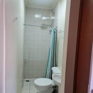 a bathroom with a shower and a toilet and a sink at Apartamento Praia das Toninhas in Ubatuba