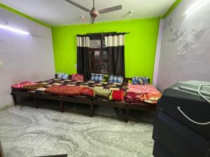 Pokój z 2 łóżkami i zieloną ścianą w obiekcie Hotel Matushri Guest House w mieście Mathura