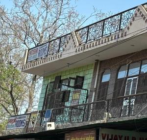 a building with a balcony on top of it at Hotel Matushri Guest House in Mathura