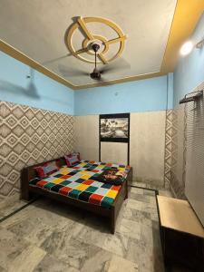 a bedroom with a bed and a ceiling fan at Hotel Matushri Guest House in Mathura