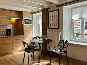 cocina con mesa y sillas en una habitación en Les Suites de l'Enclos - L'Enclos de l'Evêché en Boulogne-sur-Mer