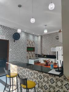 a kitchen with yellow chairs and a counter top at Casa confortável com piscina compartilhada in Aracaju