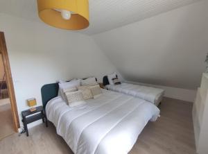 een slaapkamer met 2 bedden en witte lakens bij Chez Madeleine - Maison 11 pers. Parc arboré 3000M² in Lanobre