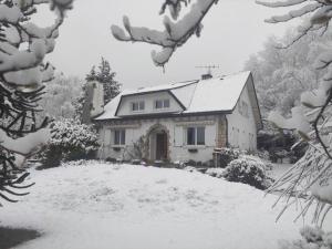 een huis bedekt met sneeuw voor een tuin bij Chez Madeleine - Maison 11 pers. Parc arboré 3000M² in Lanobre