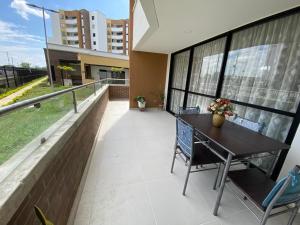 einen Balkon mit einem Tisch und Stühlen auf einem Gebäude in der Unterkunft Se alquila apartento amoblado en cali valle colombia conjunto portobelo in Cali